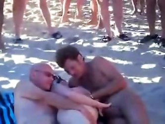 Hubby is sharing his wife with a strangers at the beach of Cap d'Agde. Lots of people is watching. More beach sex videos on x&lt;vidz69.
